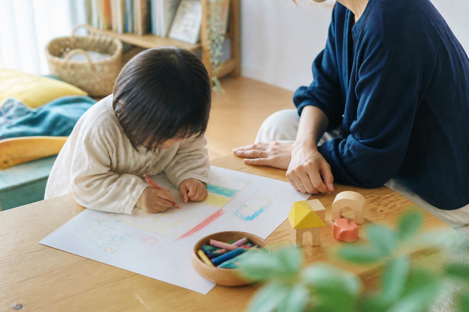 絵を描く子どもを大人がそっと見守るイメージ