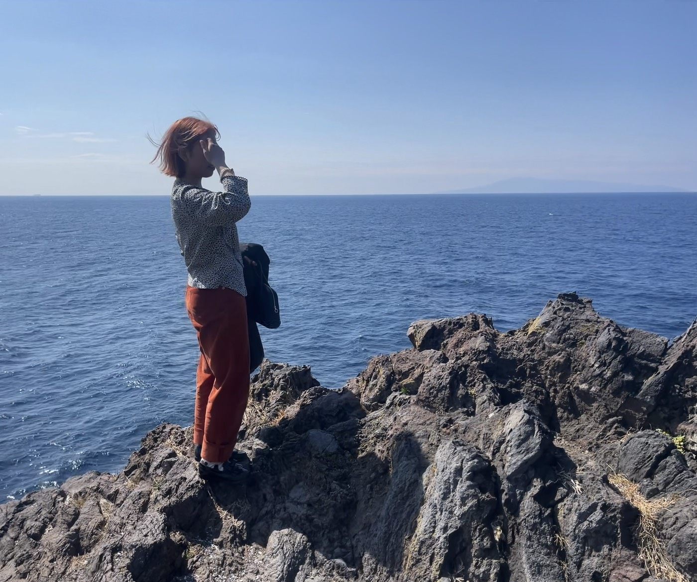 海辺の岩場に立つ代表